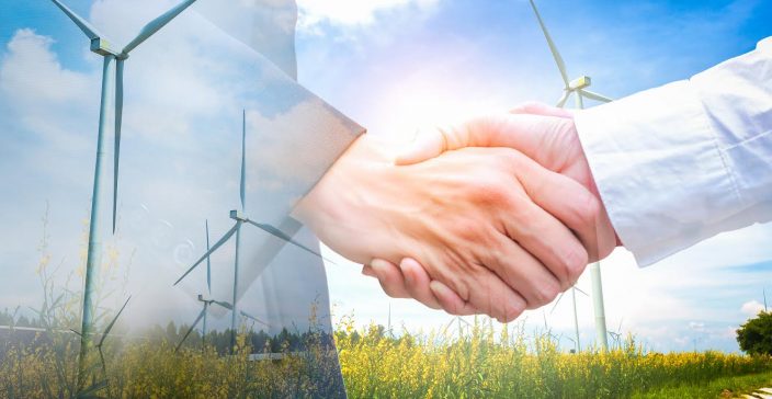 Double exposure of handshake with wind turbine. Ecology concept